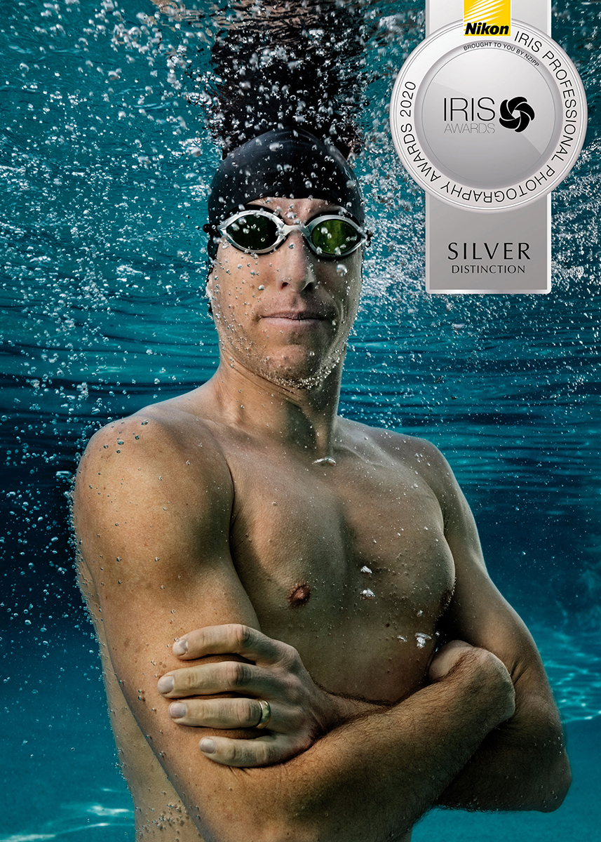 underwater photo of pro triathlete man wearing swim goggles and surrounded by bubbles