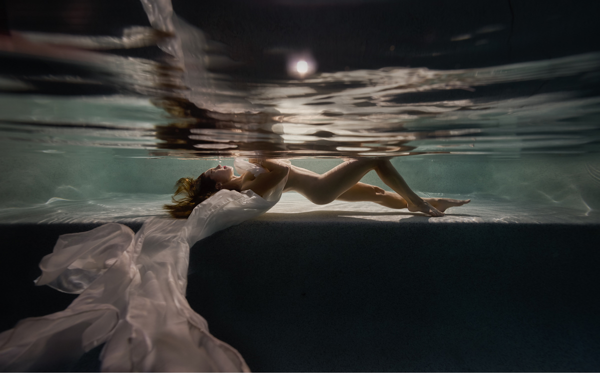 Sunshine Coast Boudoir Photographer • Underwater Specialist woman floating underwater at night with the moon showing above