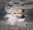 pregnant woman underwater wearing white skirt