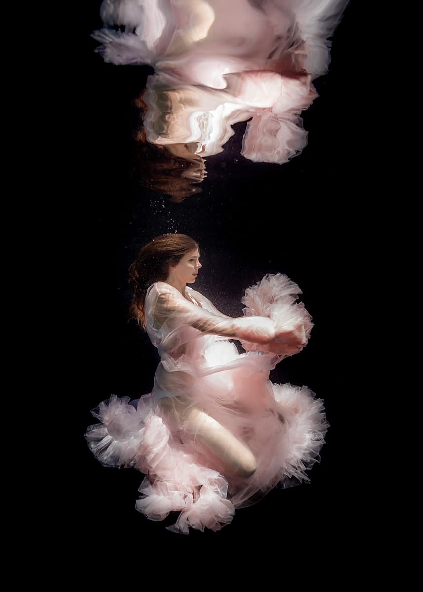 Woman underwater in a pink pouffy dress
