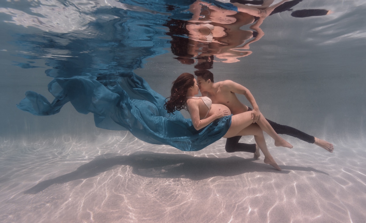 epic underwater pregnancy maternity couple with flowy dress man and woman
